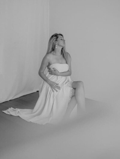 Boudoirffoto vrouw met doek zittend op bankje 