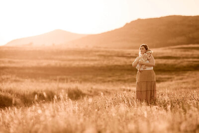 Mother looks at her baby girl in a field in Oklahoma.