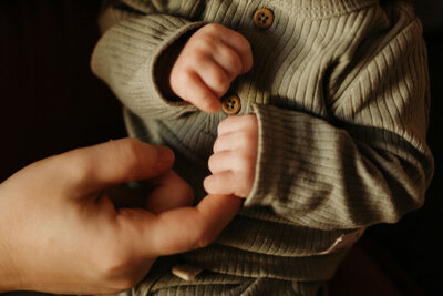 newborn baby hands holding dad's finger