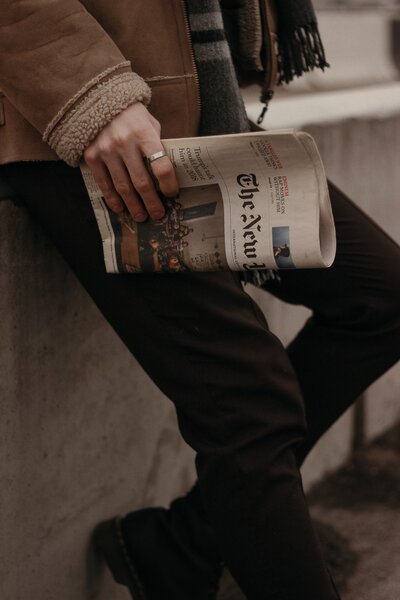 person-in-brown-coat-holding-a-news-paper-4348556