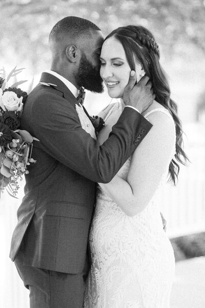 black and white image of a bride and groom snuggling during their wedding portraits at the ritz carlton laguna niguel in santa barbara california
