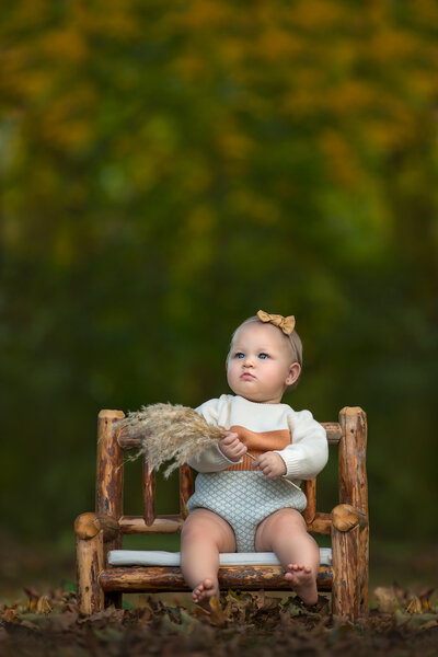 child sitting on a bench outside in mount holly, new jersey for one year old photography session.