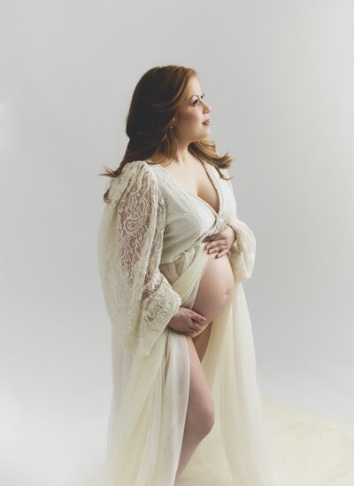 Pregnant mother in studio with beautiful white dress