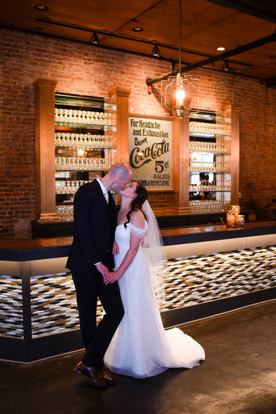 Couple kisses at The Bottling Company Hattiesburg MS Wedding
