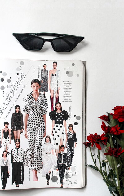 Magazine, fleurs et lunettes posées sur une surface