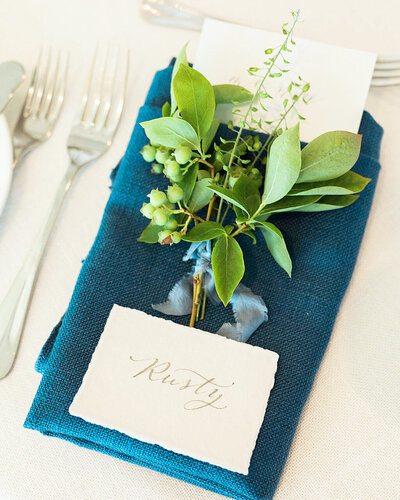 Blue napkin with handmade paper place card with calligraphy and  flower sprig for Ocean House wedding in Rhode Island