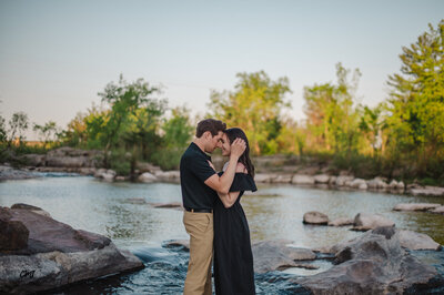 a couple hugging by a lake for photos