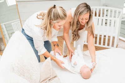 Newborn sleep coach consulting with client while changing baby
