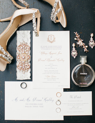 Wedding accessories and invitations with gold accents wedding shoes earrings wedding rings and perfume