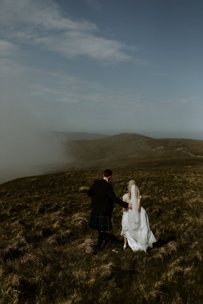 bride and groom in the hills and mist
