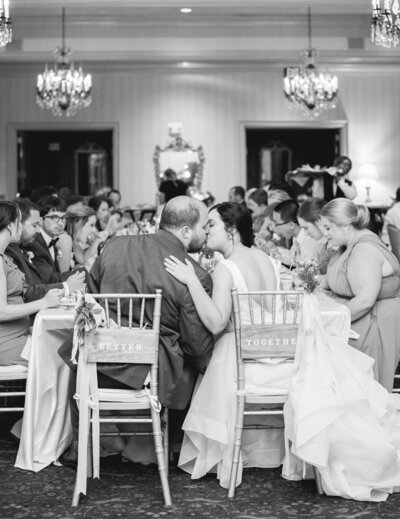 Bride and Groom kissing at the sweetheart table during a wedding reception
