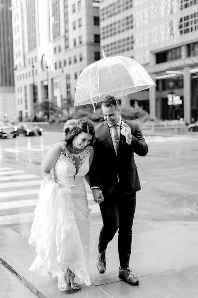 Couple holding hands under an umbrella in the rain