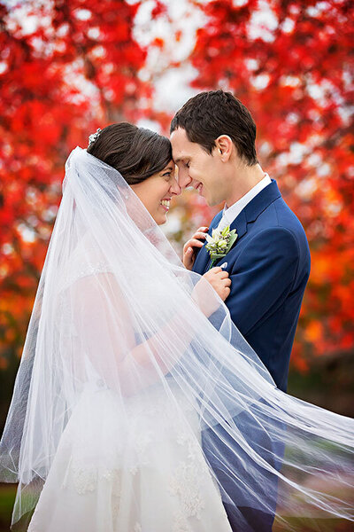 bride and groom embracing in beautiful autumn colours