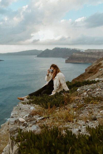 photographer in santorini greece on cliffside