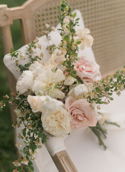seamless photography captures a luxurious floral bouquet on light birch bench. Soft pinks and cream roses for a beautiful summer wedding