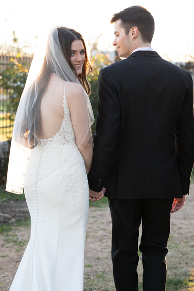 An Austin-based wedding photographer captures a couple's precious moments as the bride and groom stand on a romantic bridge.