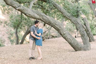 Bride to be holds her Groom's arm as the pose for photos along a trail in the Oak Canyon Nature Center in Anaheim Hills