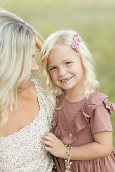 Mother holding her daughter outside.