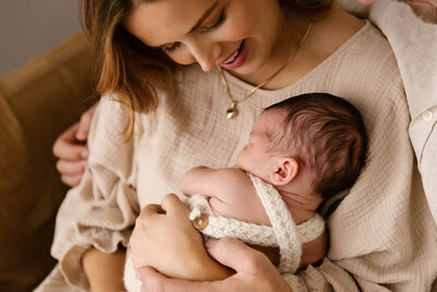 Annalee holding her baby jax during their newborn photoshoot with studio photographer aimee kelly in Taranaki