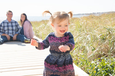Capture your toddler's joy with Lorie-Lyn Photography in Massachusetts – a candid beach portrait that celebrates the carefree spirit of childhood.