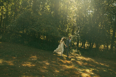 Man and woman romantically spin around, laughing in the middle of a  flowery field
