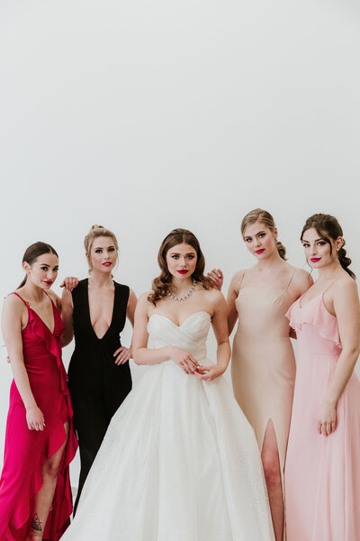 Elegant bride with bridesmaids wearing trendy colourful dresses in pink, black, blush, and peach by Cameo & Cufflinks, a contemporary bridal boutique based in Calgary, Alberta. Featured on the Brontë Bride Vendor Guide.