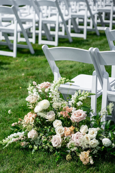 Flowers next to aisle chair, Unique Melody Events & Design helped with wedding planning