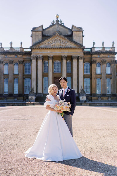bride and groom pose outside blenheim palace at their luxury event planned by westacott weddings and events