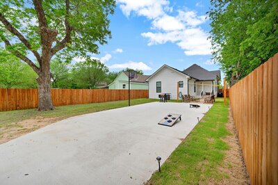 Outdoor area for entertaining at this three-bedroom, two-bathroom home with fully stocked kitchen, large backyard, grill, and basketball hoop in downtown Waco, TX.