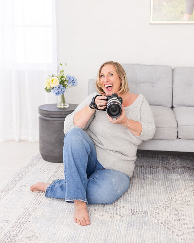 Best Boise, Idaho photographer Tiffany Hix holding a camera in her photography studio.