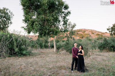Bride and Groom to be share a kiss in an open field in Santiago Oaks Regional Park in Orange during photo session