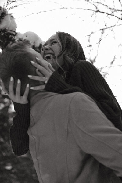 Man and woman romantically spin around, laughing in the middle of a  flowery field