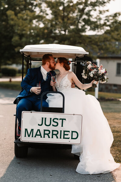The Links At Gettysburg Wedding photography in Gettysburg PA. Couple kissing on golf cart on wedding day. Just married sign,