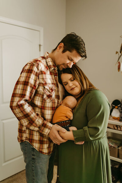 parents snuggling with their newborn baby