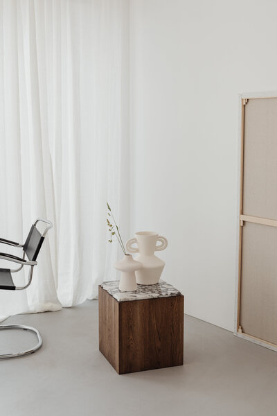 TAMI LUGER REAL ESTATE_wooden-side-table-with-marble-top-bright-ceramic-vases-concrete-floor-microcement-26601