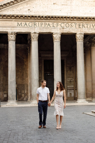 Couple holding hands walking in front of the Pantheon. Taken by Rome Photographer, Tricia Anne Photography.