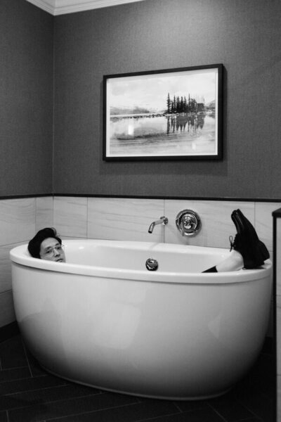 editorial style photo of groom in a bathtub in a Whistler hotel room