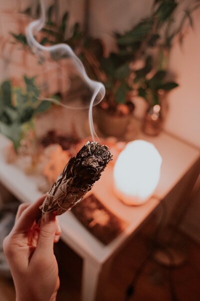 Burning sage during a smudging ritual to cleanse negative energy and promote spiritual clarity—a traditional healing practice used in holistic and shamanic ceremonies.