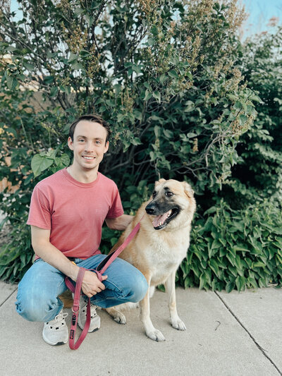 Cornerstone Dog Trainer, Zach Randall, sitting next to his German Shephard | Cornerstone Dog Training
