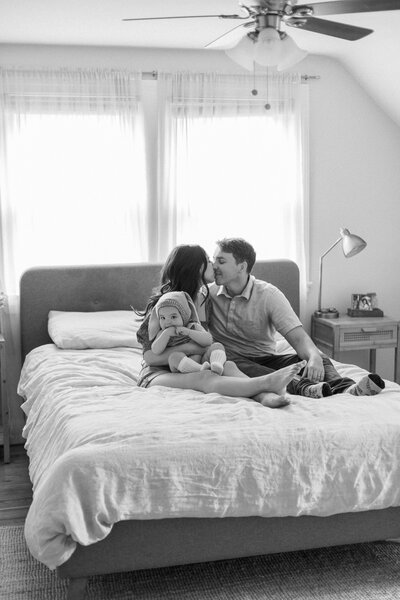 Family sits together on bed during lifestyle session in Lexington Kentucky photographed by Lexington Kentucky photographer Magnolia Tree Photo Company