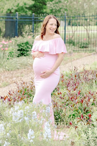 Mom is looking at her pregnant belly in Hartwood Acres  located in Wexford PA during her maternity photoshoot