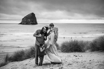 Black and white photo of family at Pacific City, Oregon for photoshoot with Portland family photographer.