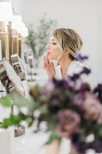 bride applying lipstick