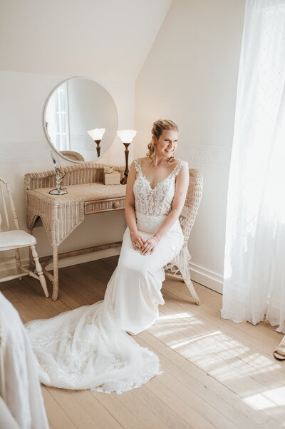 Bride sitting in chair in bridal suite