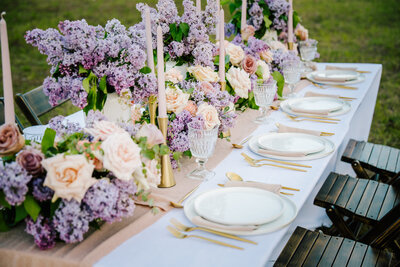 close up of purple wedding table decor with gold utensils