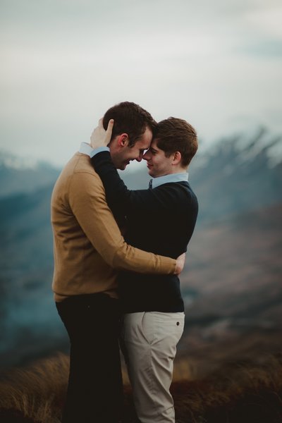 two men cuddling in the mountains