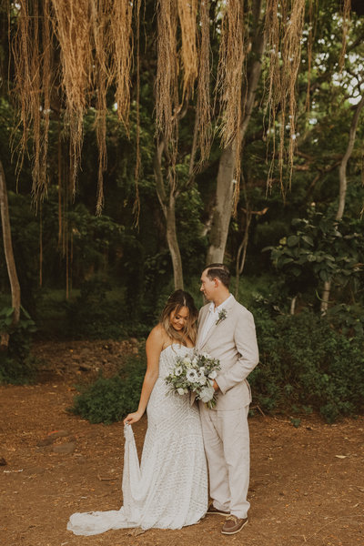 bride and groom standing in front of trees