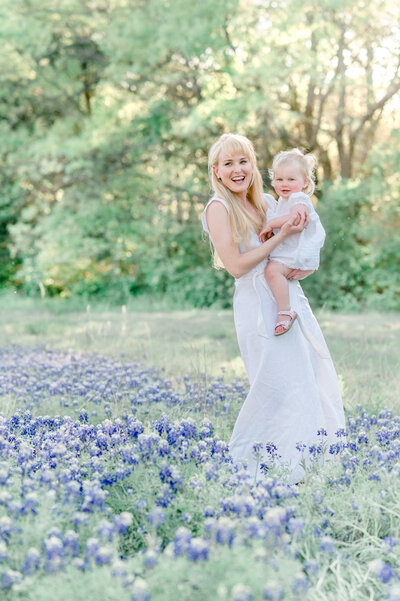 Mom dancing with her daughter in a field of bluebonnets.