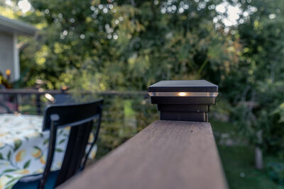 Deck railing with a TimberTech Advanced PVC drink rail and integrated post cap light. 