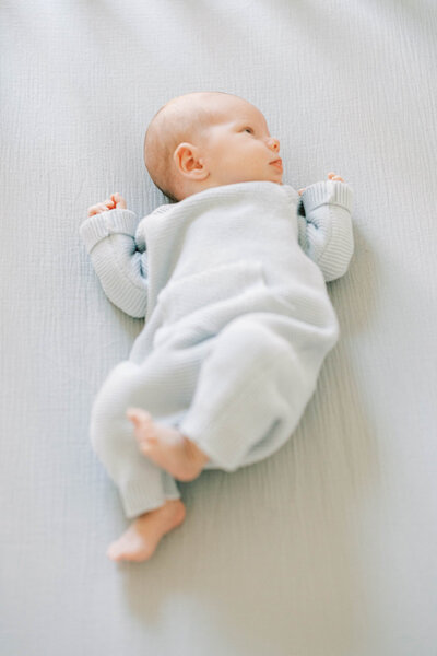 Baby in blue onesie sleeps peacefully in his Lancaster, PA nursery